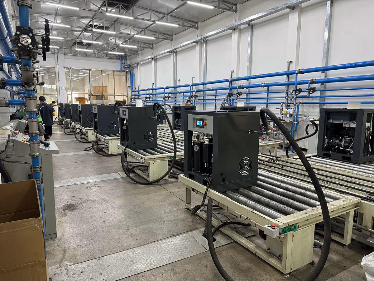 Screw compressors on roller conveyors inside a workshop